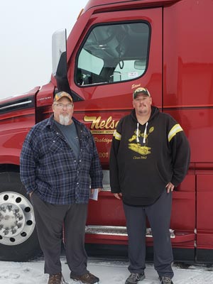 Two drivers standing in front of truck door